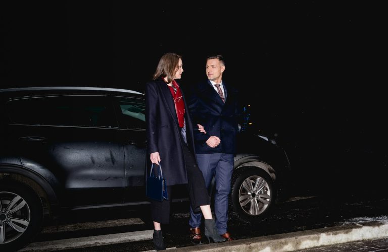 couple holding hands and looking at each other with car on background