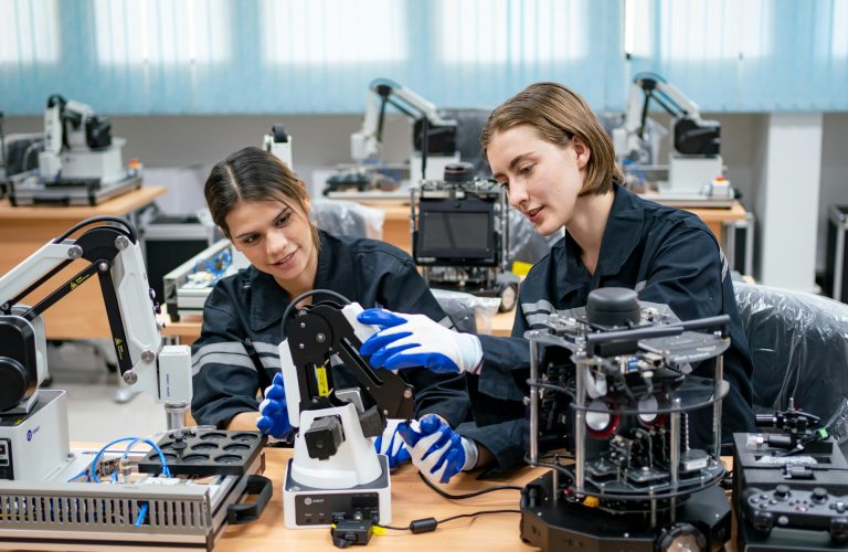 Female Engineer Man working at industrial robot in factory industrial. robotic and manufacturing