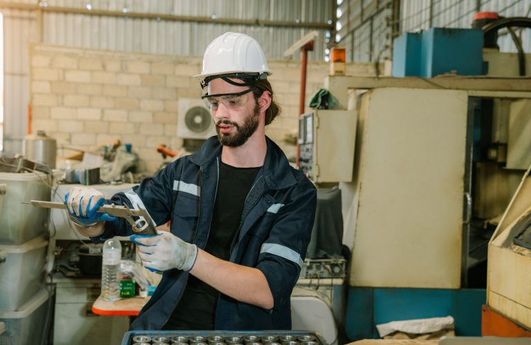 Industrial engineer wearing a white helmet working in industrial factory.