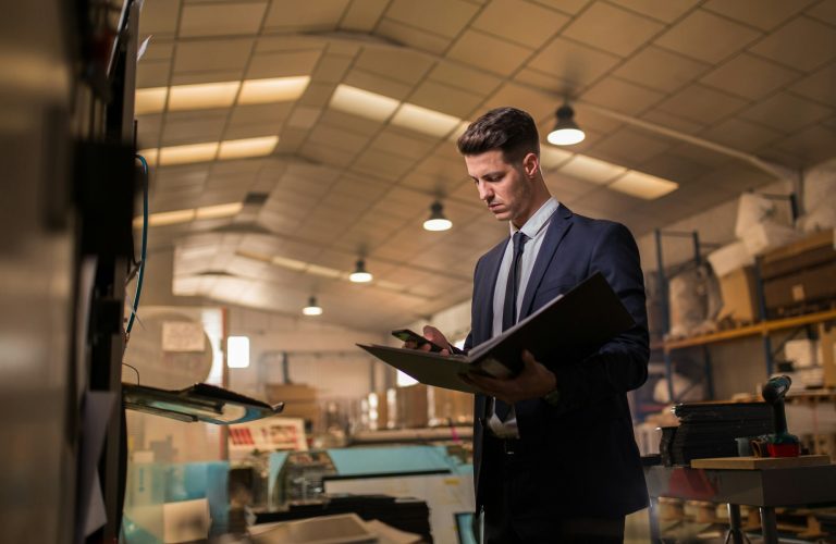Young man in suit inspecting industrial sector
